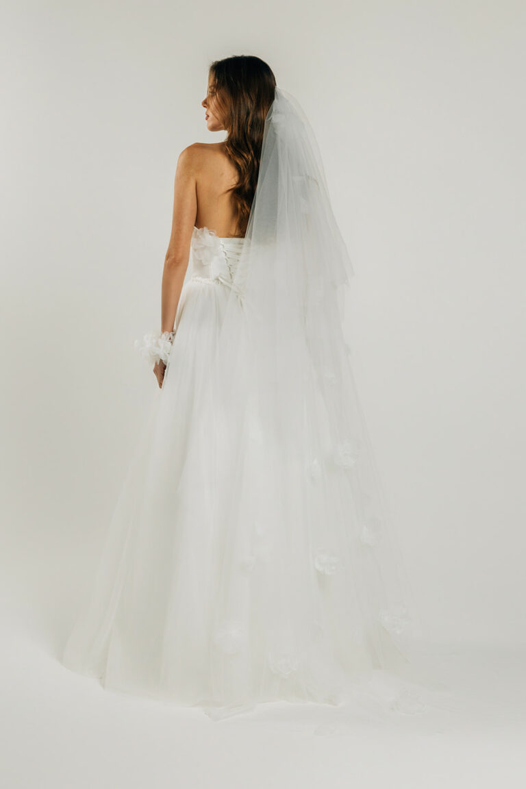 femme dans une robe de mariée A-line épurée avec des fleurs