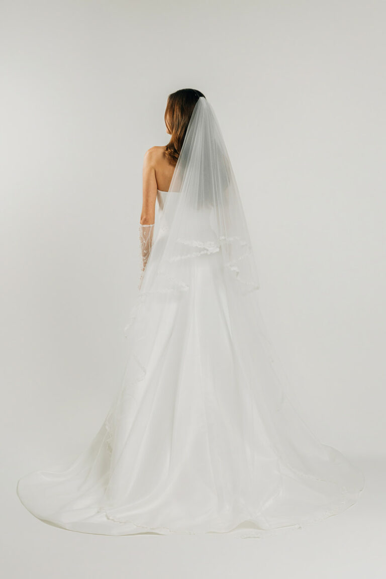 femme dans une robe de mariée A-line épurée avec décolleté cœur et un voile