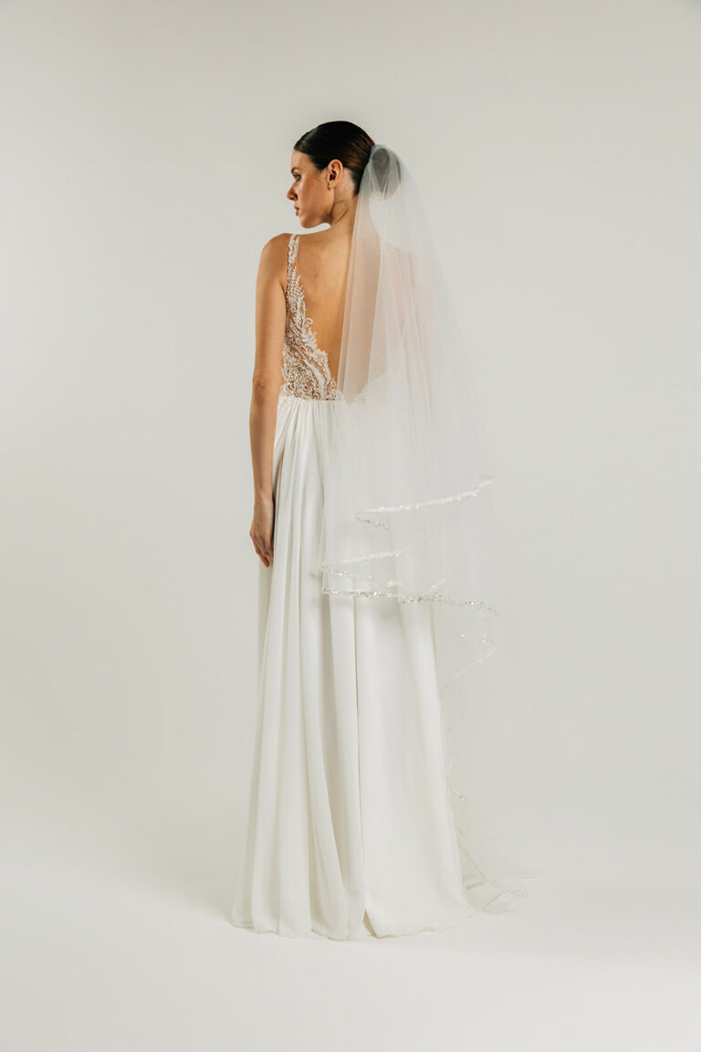 femme dans une robe de mariée fluide à bretelles style bohème avec un voile