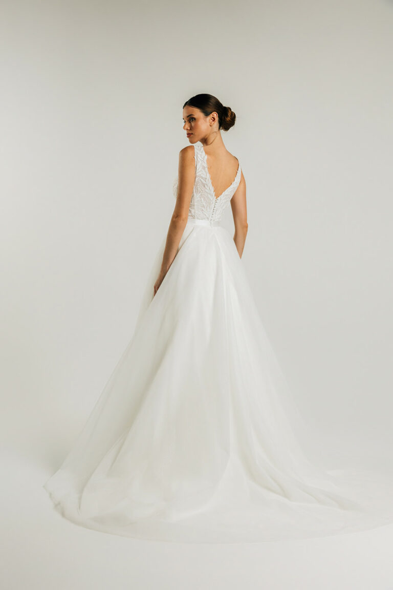 femme dans une robe de mariée A-line épurée avec une sujrupe