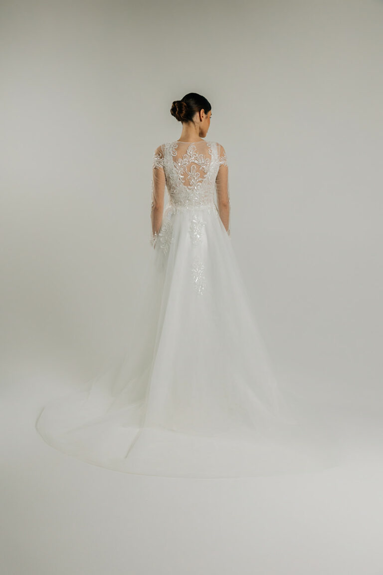 femme dans une robe de mariée sirène brillante avec une traîne à broderies