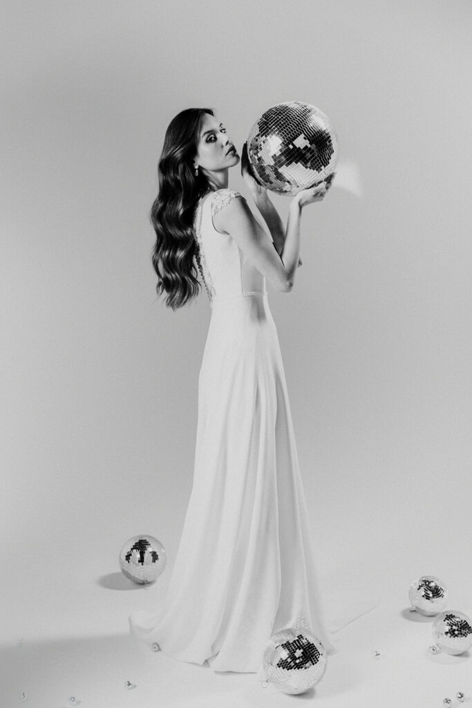 femme dans une robe de mariée épurée et brillante avec des boules à facettes