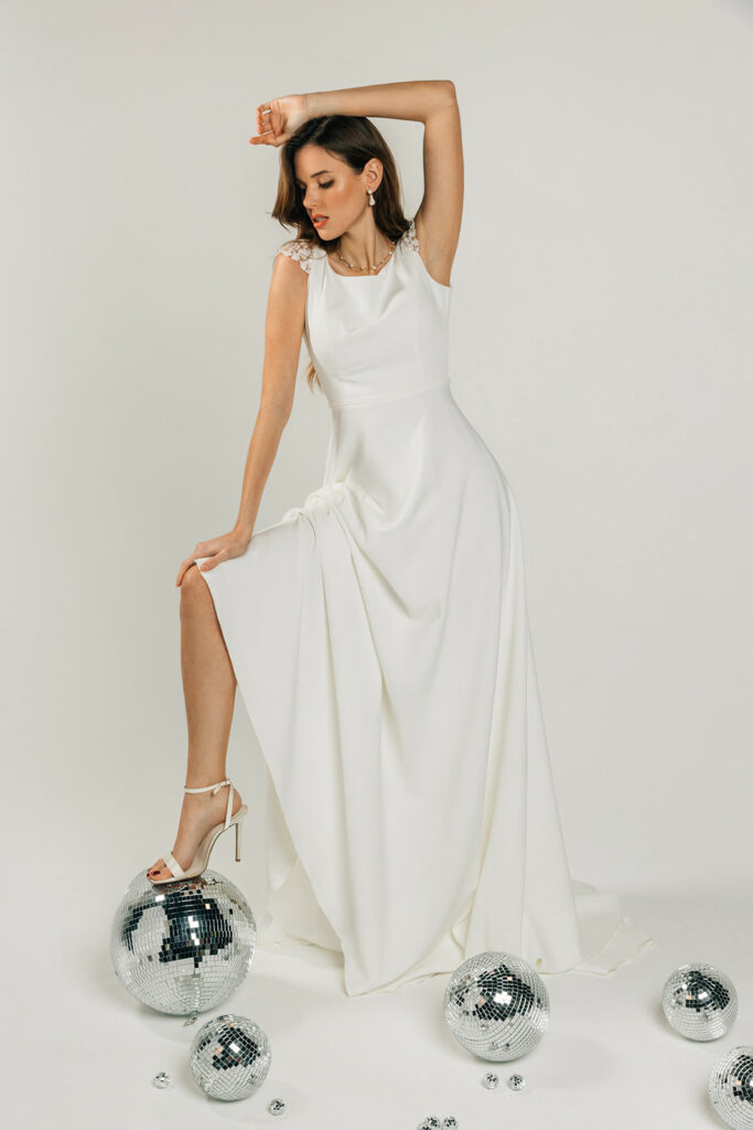 femme dans une robe de mariée épurée et brillante avec des boules à facettes
